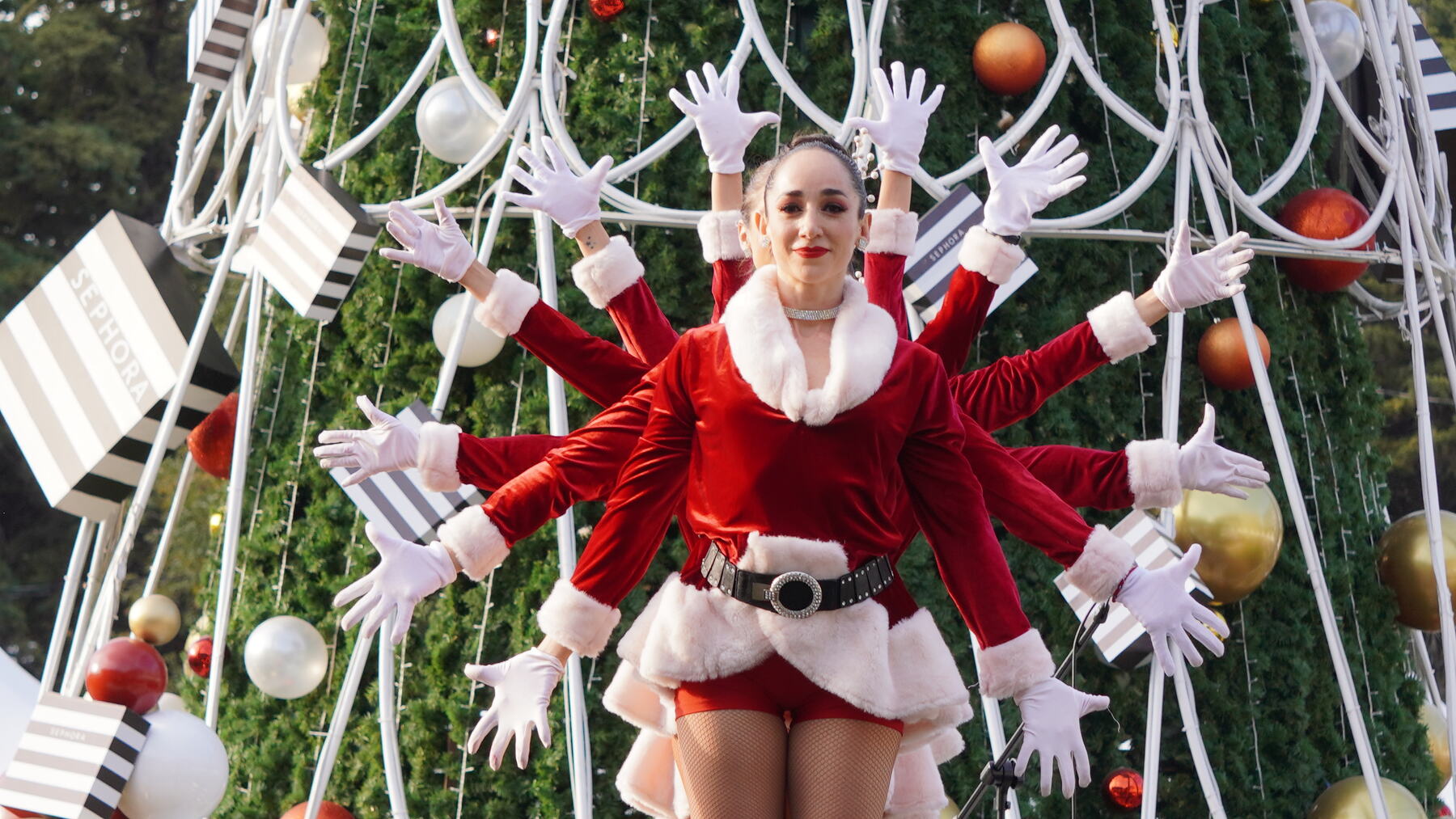 Rockettes navideñas de Pas de Dance frente a un árbol de Navidad gigante